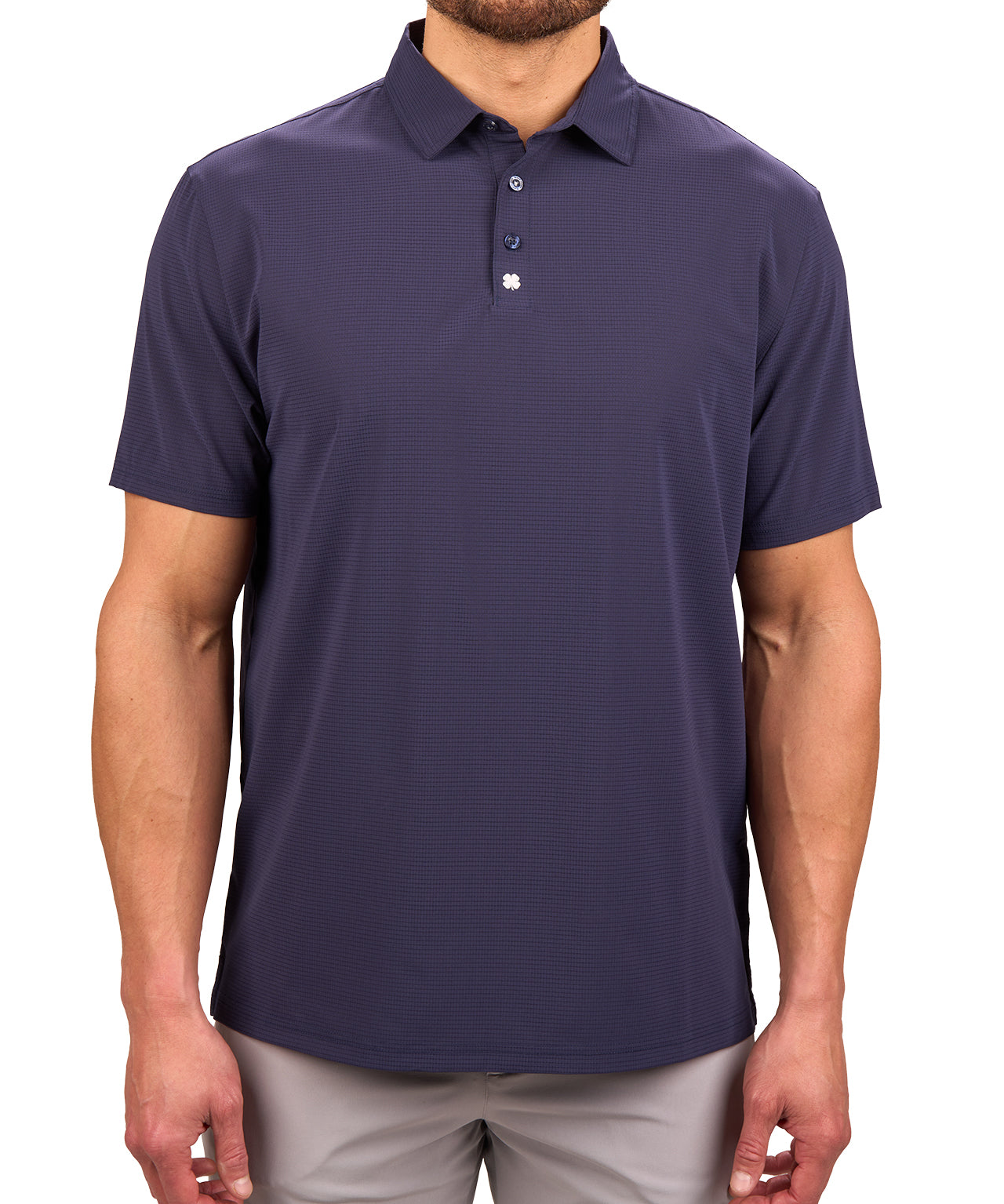 Man wearing navy polo from Black Clover with a small clover near the buttons