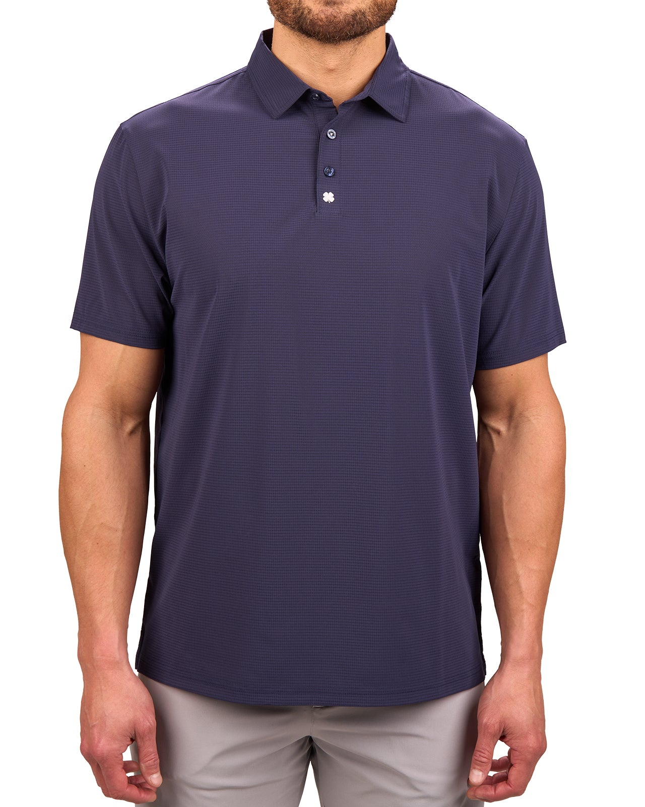 Man wearing navy polo from Black Clover with a small clover near the buttons