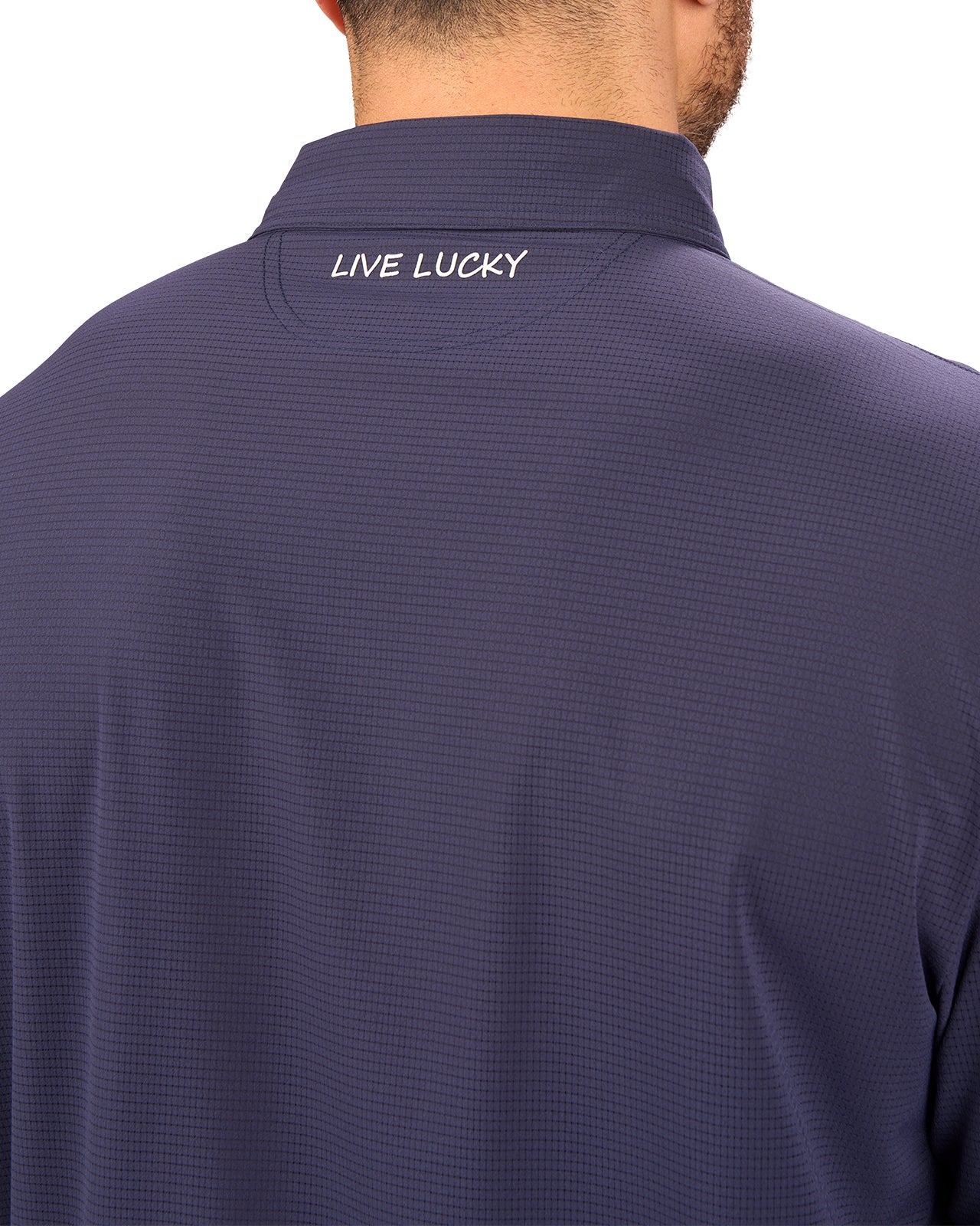 Man wearing navy polo from Black Clover with a small clover near the buttons