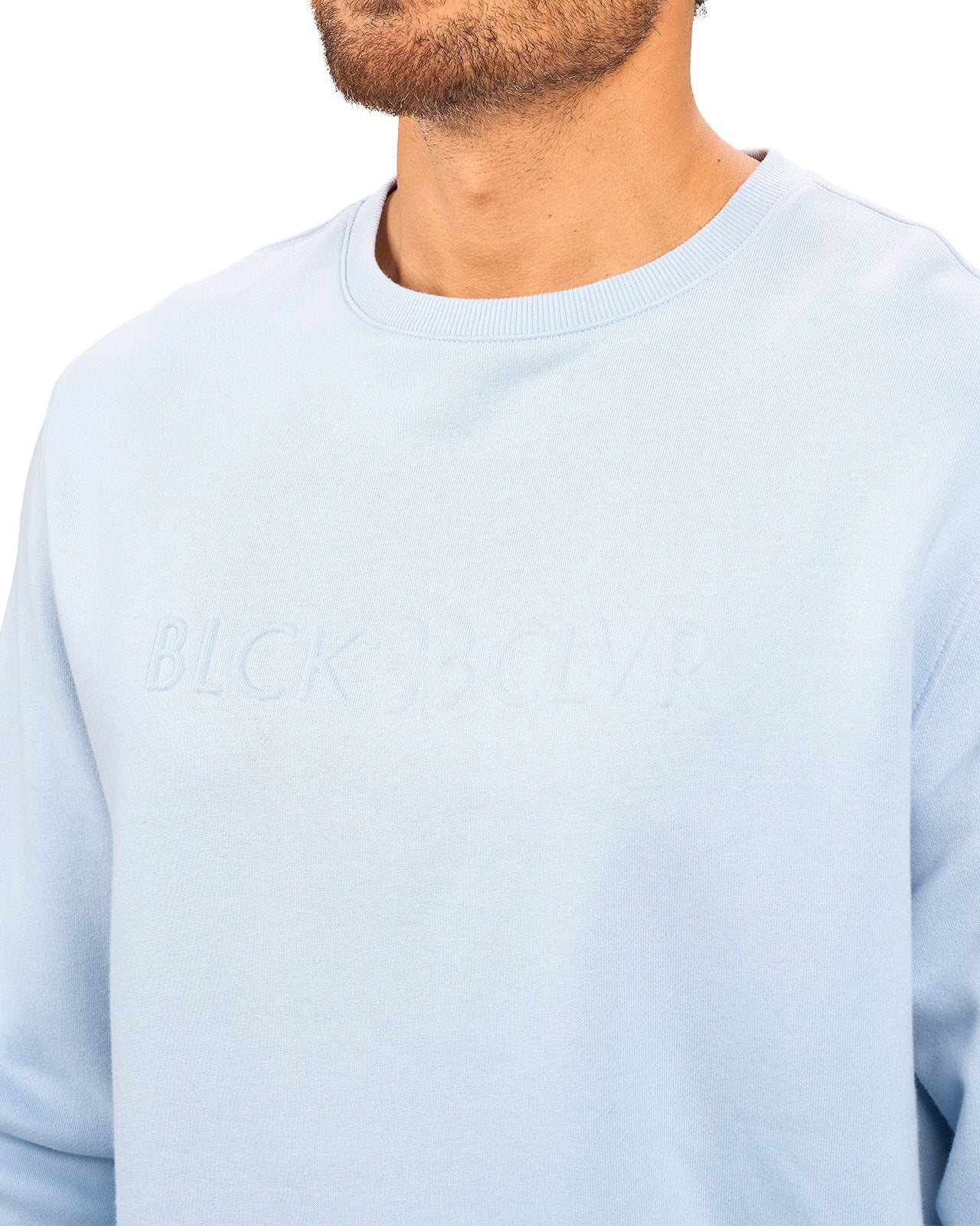man wearing an light blue colored sweater from Black Clover with a 3d text BLCK CLVR on the chest