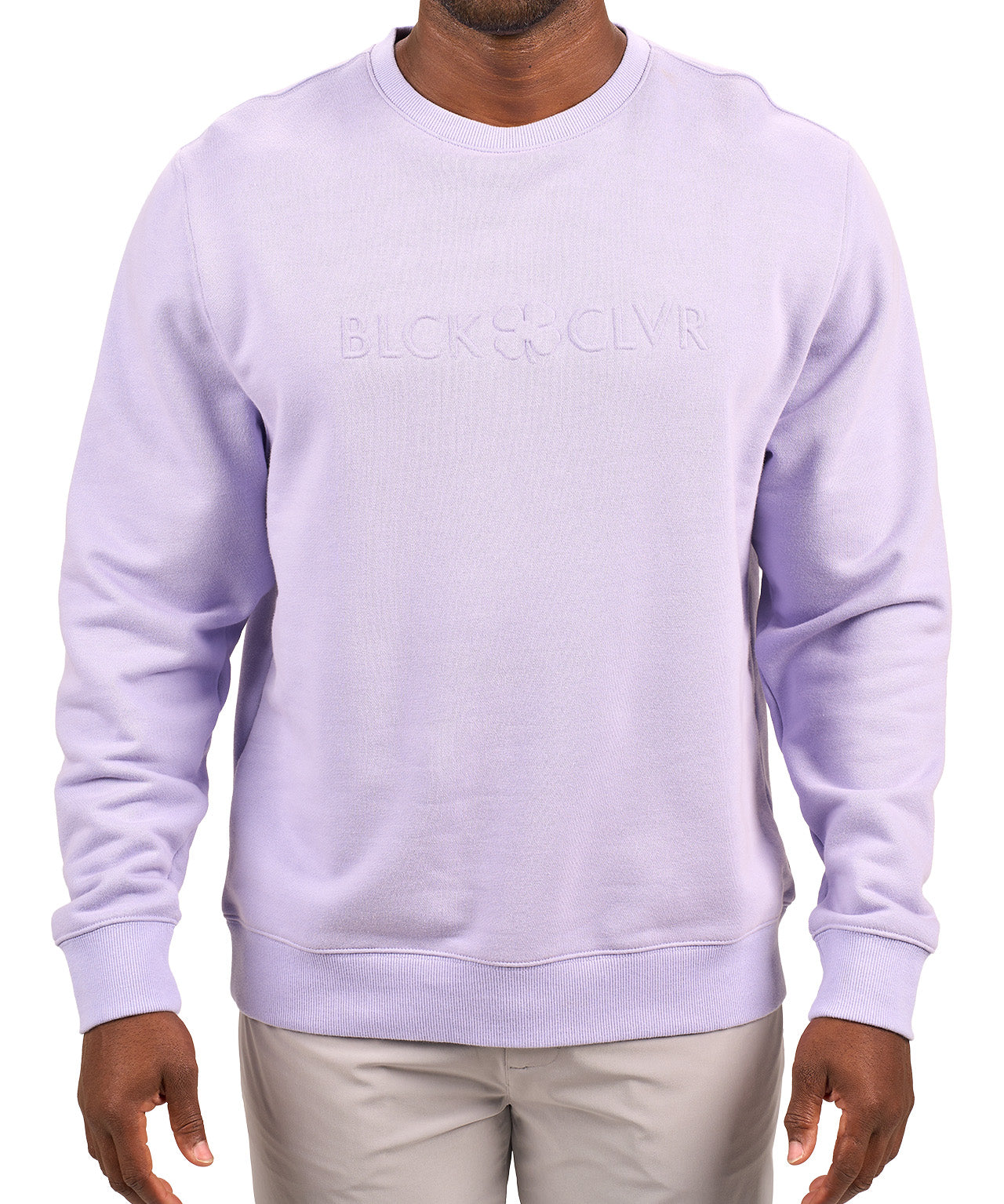 man wearing an light purple colored sweater from Black Clover with a 3d text BLCK CLVR on the chest