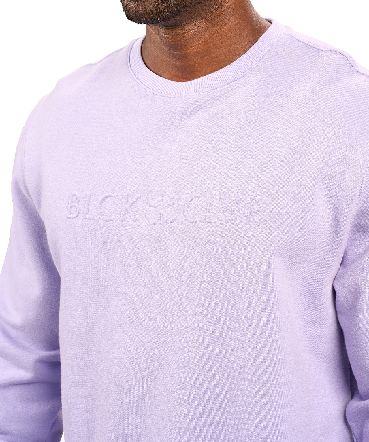 man wearing an light purple colored sweater from Black Clover with a 3d text BLCK CLVR on the chest