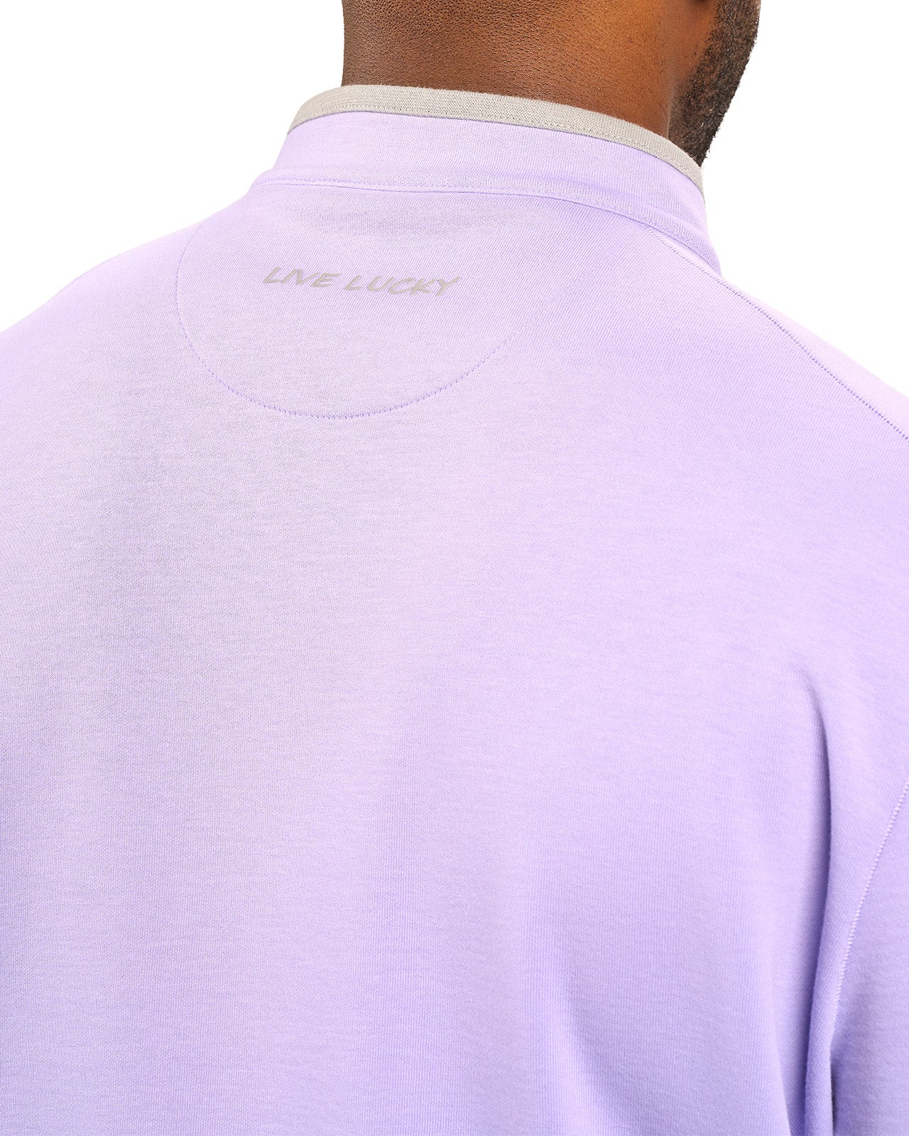 Man wearing a light purple quarter zip sweater from Black Clover featuring a small clover below the zipper