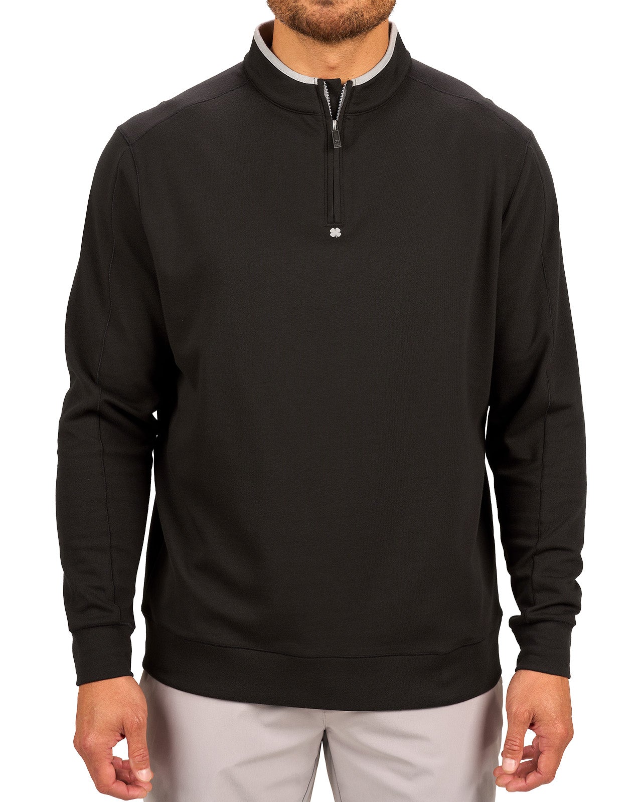 Man wearing a black quarter zip sweater from Black Clover featuring a small clover below the zipper