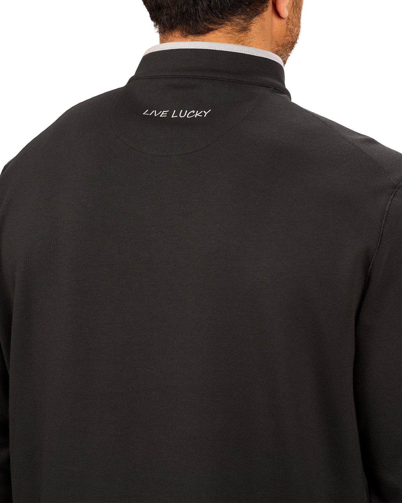 Man wearing a black quarter zip sweater from Black Clover featuring a small clover below the zipper