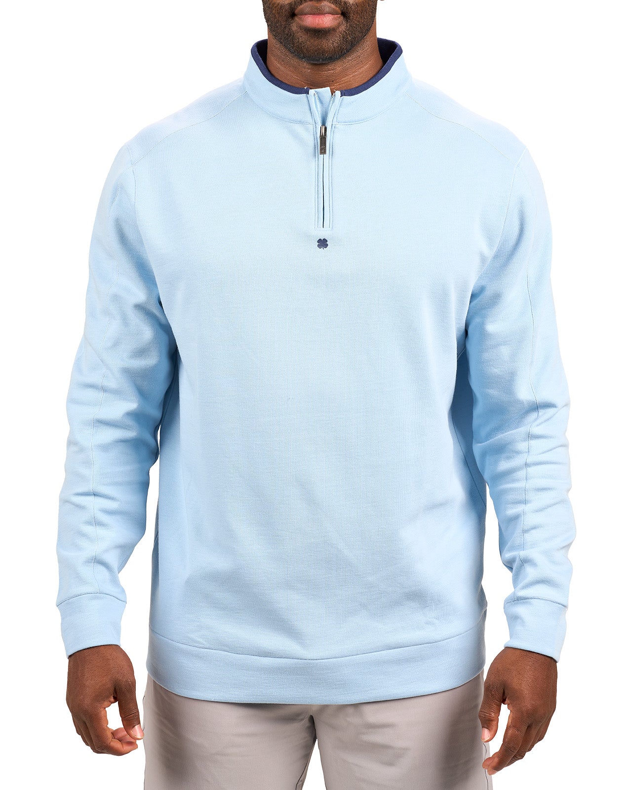 Man wearing a light blue quarter zip sweater from Black Clover featuring a small clover below the zipper