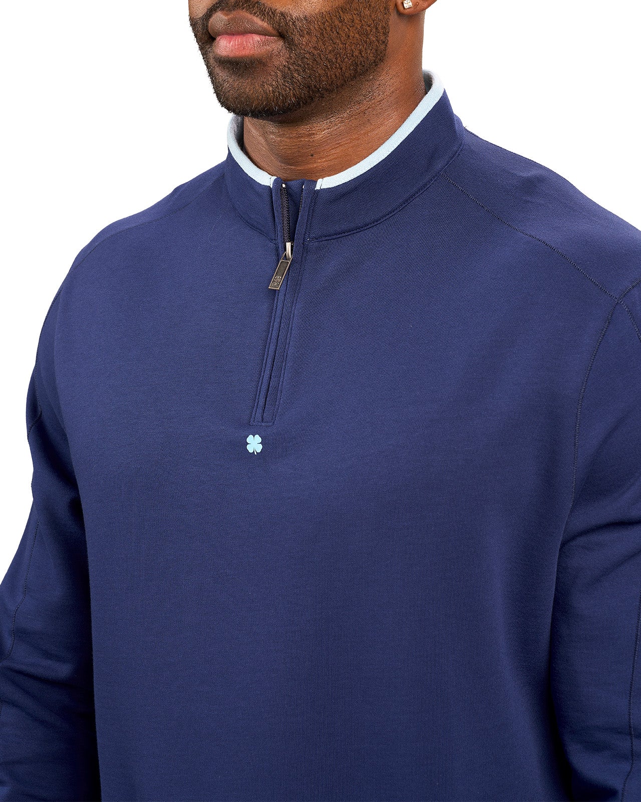 Man wearing a navy quarter zip sweater from Black Clover featuring a small clover below the zipper