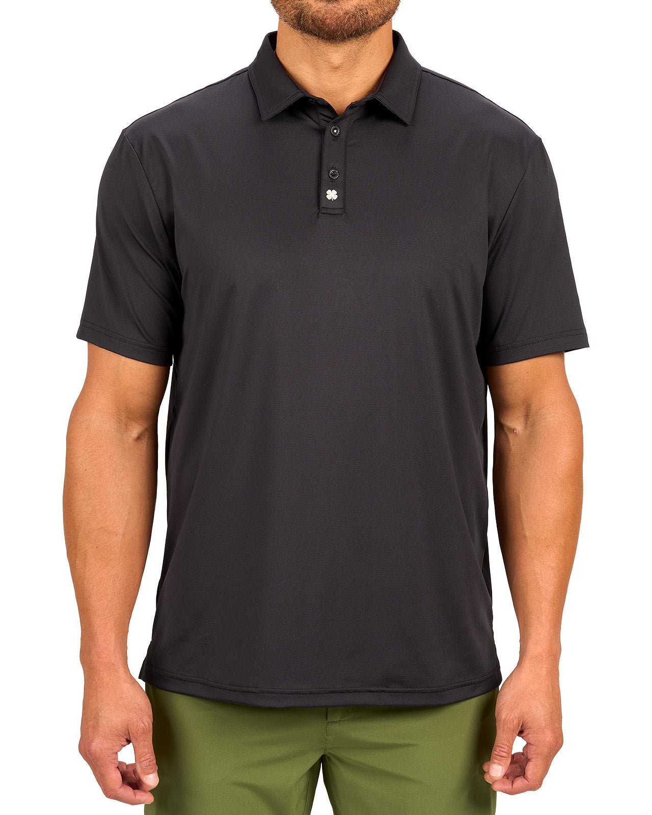 Man wearing black polo from black clover featuring a small clover logo below the bottom button