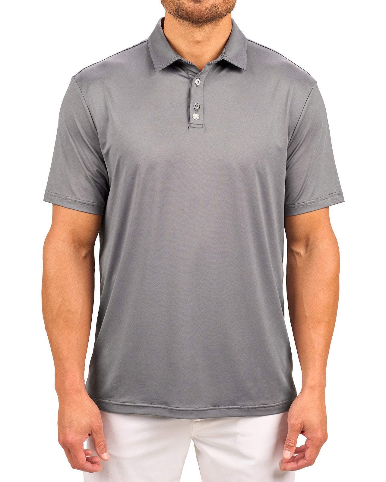 Man wearing charcoal grey polo from black clover featuring a small clover logo below the bottom button