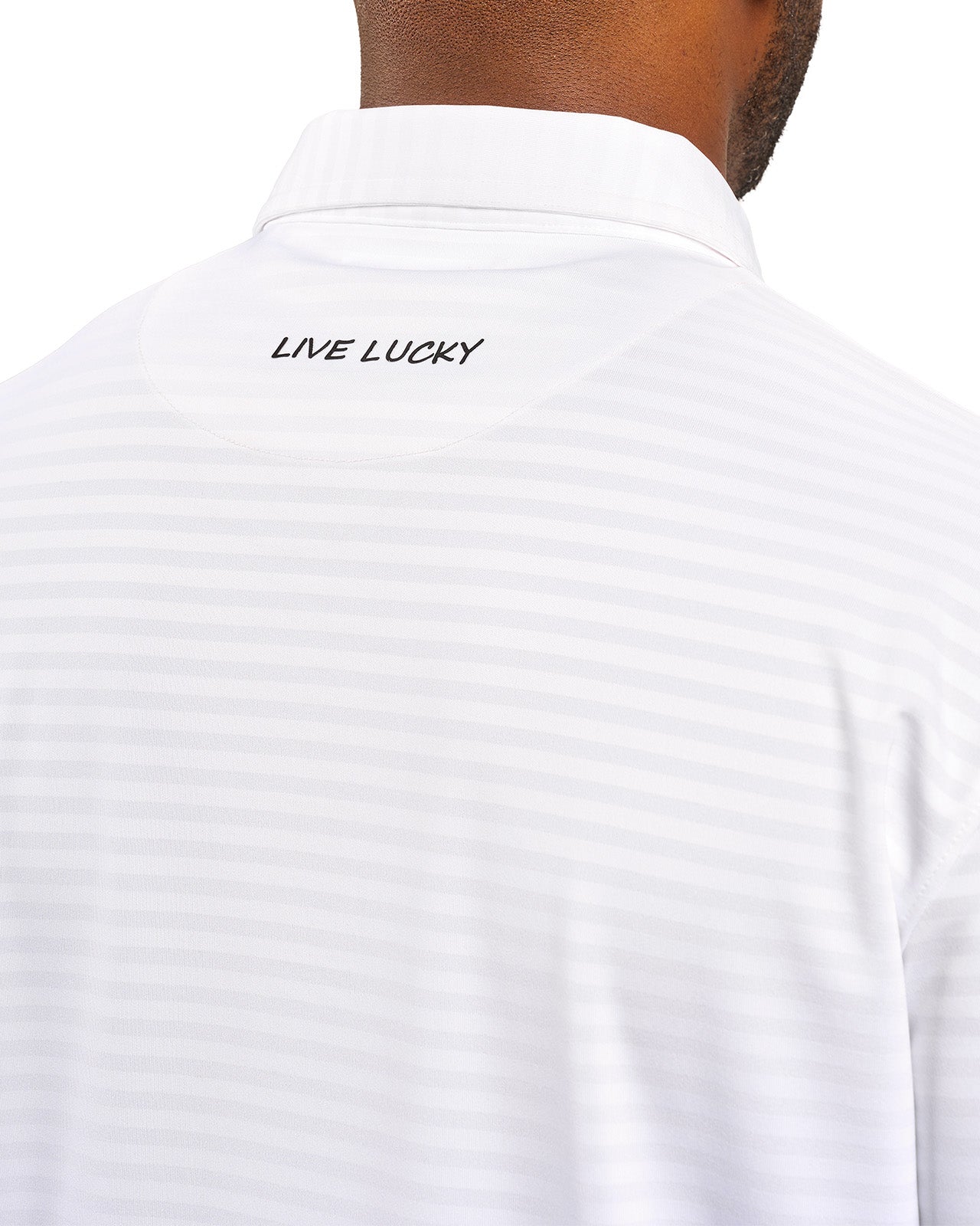 Man wearing striped white polo from Black Clover featuring small clover logo below the bottom button