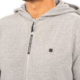 Man wearing oatmeal colored zip up hoodie from Black Clover featuring small clover icon on the left chest