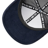 blue corduroy hat with a patch depicting a mountain ridgeline