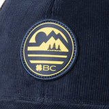 blue corduroy hat with a patch depicting a mountain ridgeline