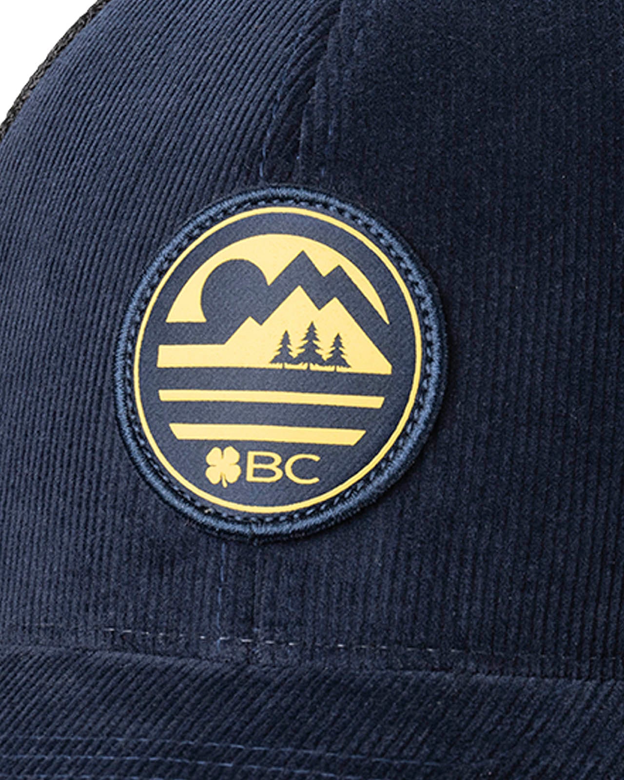 blue corduroy hat with a patch depicting a mountain ridgeline